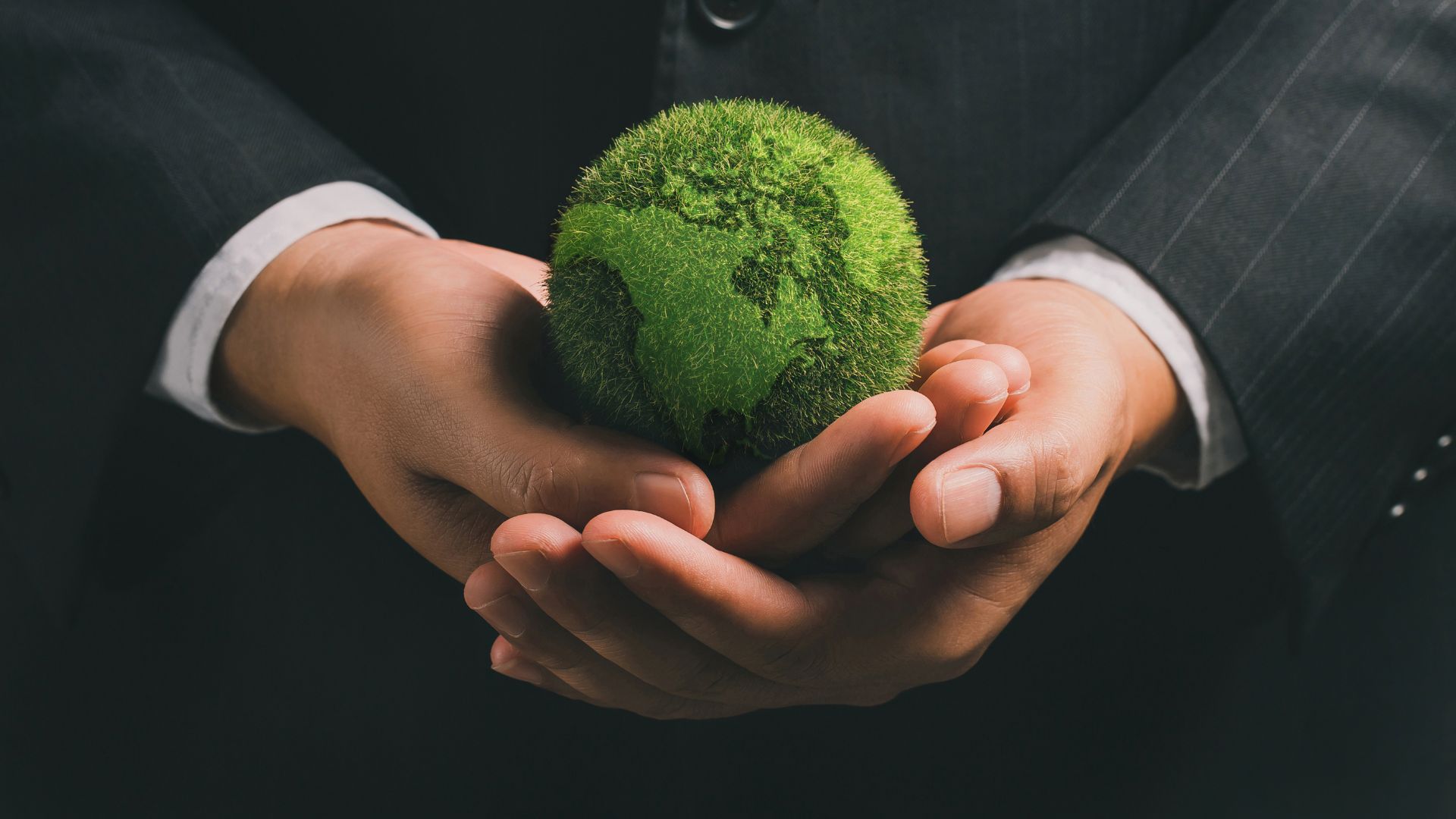 Man in suit holding a thriving earth